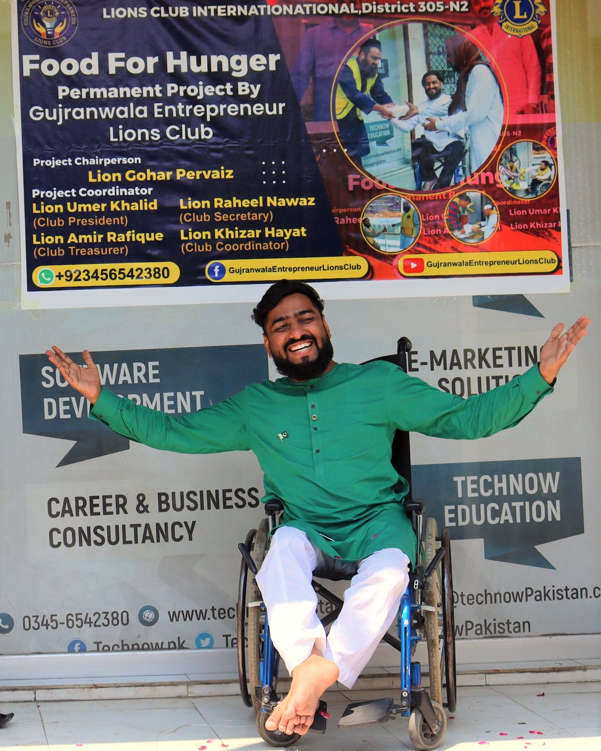 Raheel Nawaz smiling with arms wide open in his wheelchair outside the TechNow Pakistan office